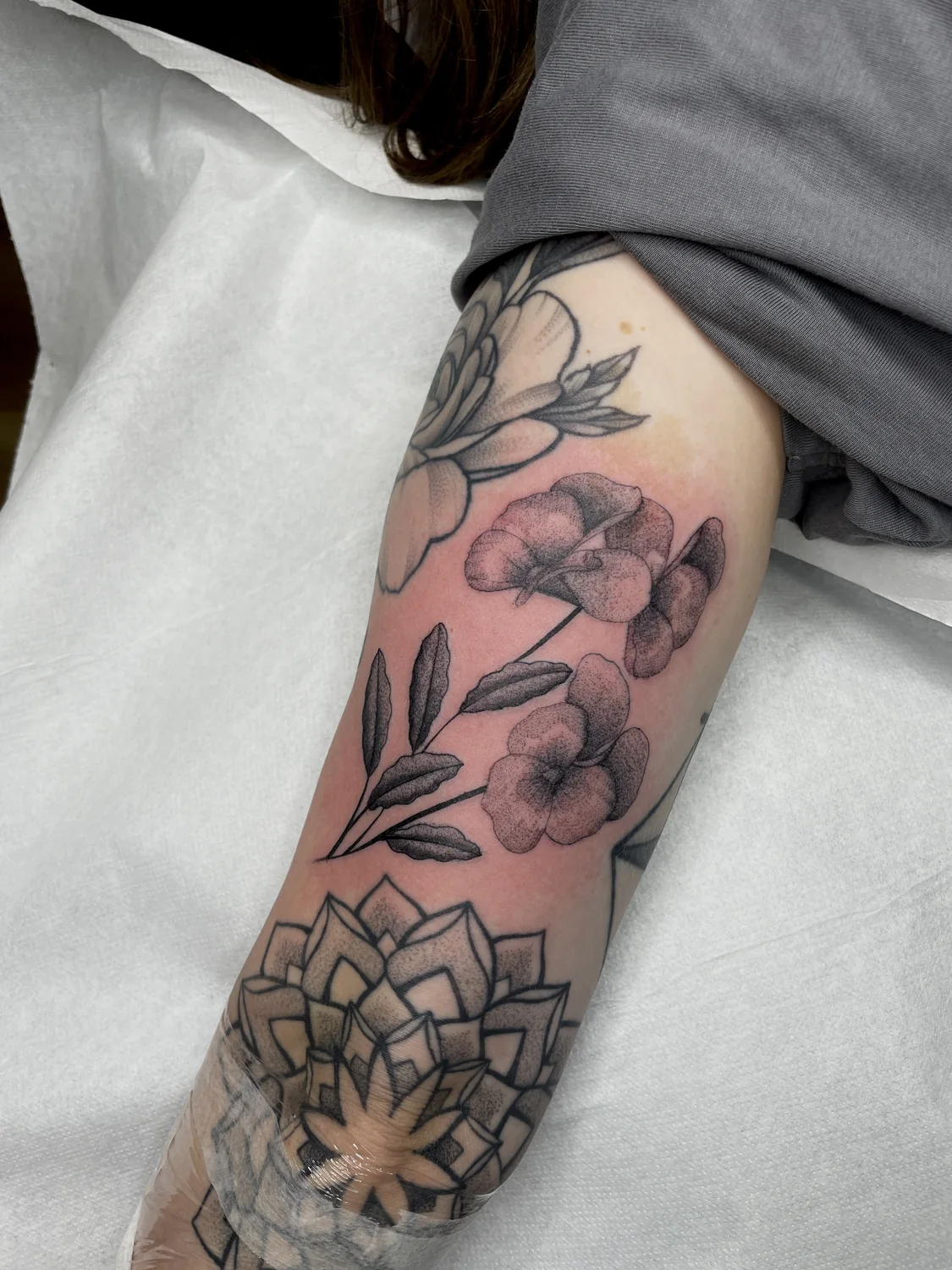 Feine Blüten und Dotwork-Mandala am Bein von Marius